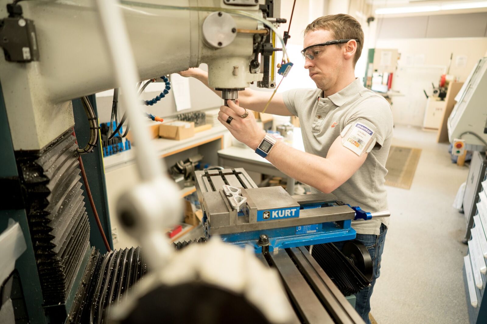 A student wearing safety glasses works with a large piece of equipment.