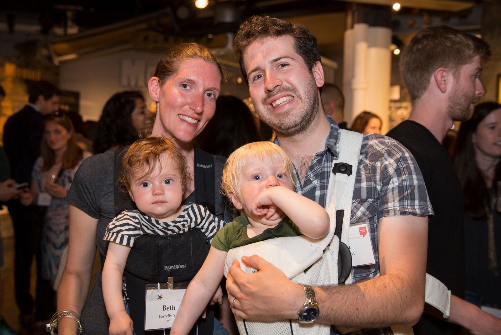 A couple of alumni hold their young children.