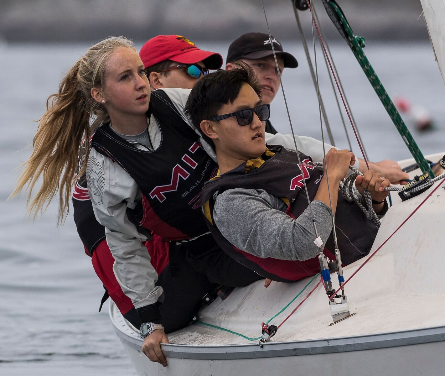 Four students navigate a sailboat.